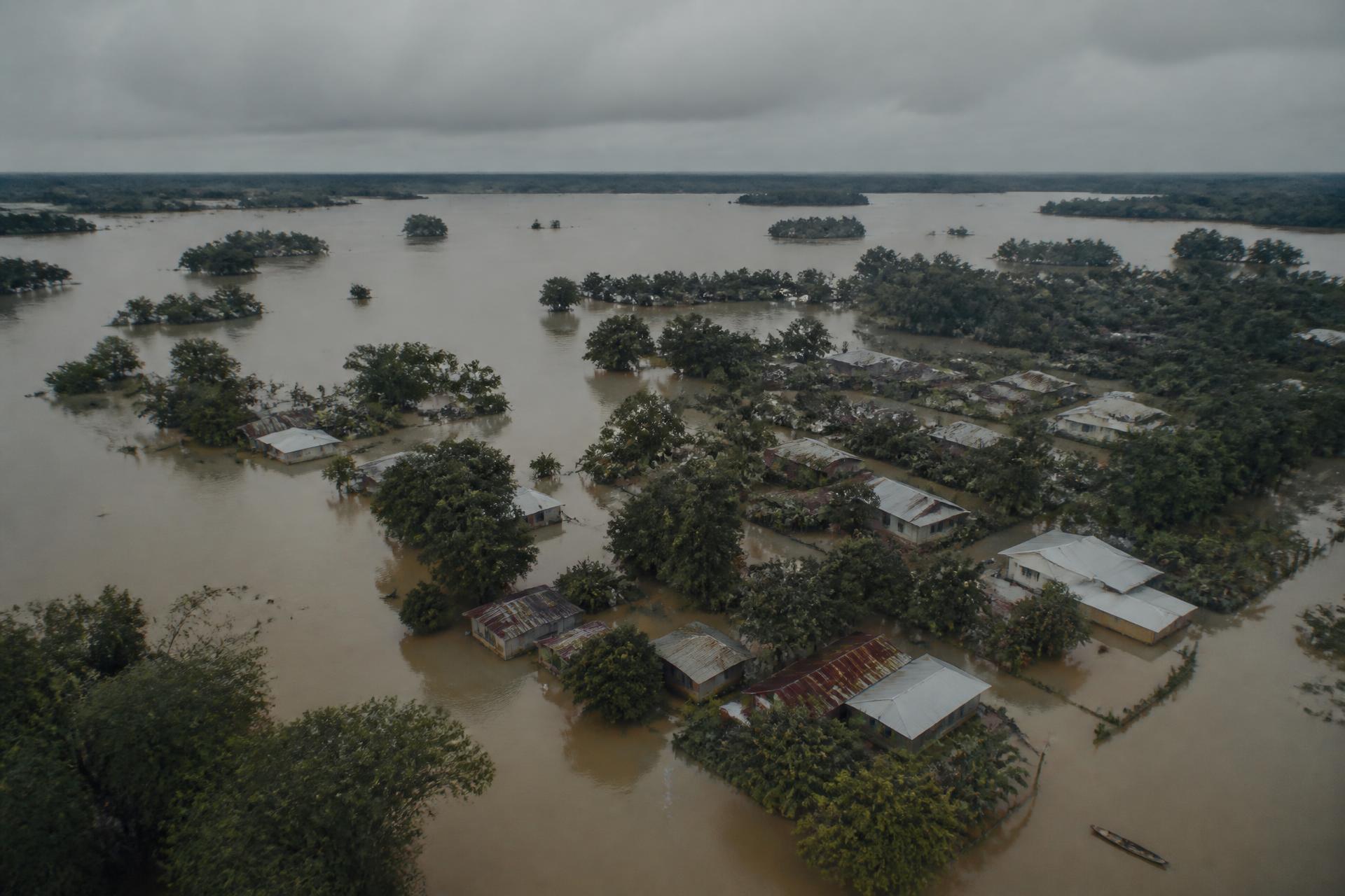 Aerial view of flood-affected homes in Assam surrounded by muddy monsoon waters.